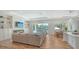 Open-concept living room with lots of natural light, tray ceilings, wood-look tile flooring, and access to outdoor patio at 6136 Hollywood Blvd, Sarasota, FL 34231