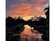 Serene waterfront view features a fiery sunset sky, calm waters, and boats docked along the canal at 6136 Hollywood Blvd, Sarasota, FL 34231