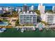 Stunning aerial view of waterfront condominium with boat docks, pool, and cityscape in the background at 650 Golden Gate Pt # 602, Sarasota, FL 34236