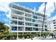 Upscale, modern condominium featuring multiple balconies with glass railings and verdant landscaping at 650 Golden Gate Pt # 602, Sarasota, FL 34236