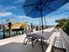 Relaxing waterfront patio with comfortable seating and marina views, shaded by a large umbrella at 650 Golden Gate Pt # 602, Sarasota, FL 34236