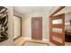 Entryway with stone tile floor, large mirror, and front door with modern door frame at 650 Golden Gate Pt # 602, Sarasota, FL 34236