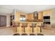 Modern kitchen island featuring barstool seating, maple cabinets, and stainless-steel appliances for a functional space at 650 Golden Gate Pt # 602, Sarasota, FL 34236