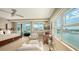 Serene main bedroom featuring waterfront views, a sitting area, and plenty of natural light for a relaxing space at 650 Golden Gate Pt # 602, Sarasota, FL 34236
