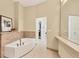 Bright bathroom features a soaking tub, stone tile floor, and view of walk-in closet at 6512 Midnight Pass Rd # 504, Sarasota, FL 34242