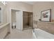 Bright bathroom with a soaking tub, glass shower, and decorative tile at 6512 Midnight Pass Rd # 504, Sarasota, FL 34242