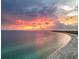 A scenic view of the coastline and ocean with a colorful sunset sky at 6512 Midnight Pass Rd # 504, Sarasota, FL 34242