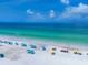 Scenic view of the beach, featuring umbrellas dotting the white sand and blue ocean at 6512 Midnight Pass Rd # 504, Sarasota, FL 34242