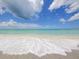 Calm beach waves and sandy shoreline under a clear blue sky at 6512 Midnight Pass Rd # 504, Sarasota, FL 34242