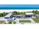 Aerial view of the beach with a modern building featuring a large outdoor area and palm trees at 6512 Midnight Pass Rd # 504, Sarasota, FL 34242
