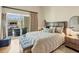 Bedroom with a large bed, bench, and a balcony overlooking the outdoors at 6512 Midnight Pass Rd # 504, Sarasota, FL 34242