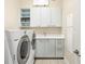 Clean laundry room featuring a washer, dryer, ample storage cabinets, and a sink at 6512 Midnight Pass Rd # 504, Sarasota, FL 34242