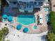 Aerial view of a resort-style pool and spa, surrounded by lounge chairs and lush landscaping at 6512 Midnight Pass Rd # 504, Sarasota, FL 34242