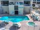 Aerial view of a stunning pool area with a spa, lounge chairs, and shady umbrellas at 6512 Midnight Pass Rd # 504, Sarasota, FL 34242