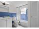 Clean bathroom with blue tile accents, a shower-tub combo, and a classic white vanity at 6520 Clemson St, Bradenton, FL 34207