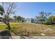 Charming single-story home with a light blue and white color scheme, complemented by tropical landscaping at 6520 Clemson St, Bradenton, FL 34207