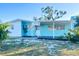 Light blue single-story home featuring a covered front porch with white support columns and a dark wood-stained deck at 6520 Clemson St, Bradenton, FL 34207