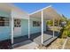 Cozy covered front porch features light blue siding, white trim, a decorative wreath, and a gray deck at 6520 Clemson St, Bradenton, FL 34207