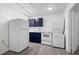 Efficient kitchen with blue cabinets, modern appliances, and adjacent laundry, maximizing space and function at 6520 Clemson St, Bradenton, FL 34207