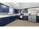 Modern kitchen featuring dark blue cabinets, stainless steel appliances, and stylish tile backsplash at 6520 Clemson St, Bradenton, FL 34207