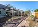 Outdoor pool area with screening, brick pavers, and a view of the fenced backyard at 6520 Clemson St, Bradenton, FL 34207