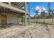 Ground-level exterior view of home showcasing its foundation and spacious outdoor area with palm trees at 6924 Bochi Cir, Sarasota, FL 34242