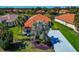 Beautiful aerial view of the house featuring an orange tiled roof, green lawn, and meticulous landscaping at 708 Foggy Morn Ln, Bradenton, FL 34212
