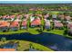 An aerial view shows a home with a red tile roof situated on a beautiful lake at 708 Foggy Morn Ln, Bradenton, FL 34212