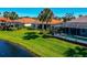 Rear view of home features a screened lanai, backyard, and a lake view at 708 Foggy Morn Ln, Bradenton, FL 34212