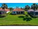 Rear view of home with verdant lawn, trimmed hedges, and beautiful water views at 708 Foggy Morn Ln, Bradenton, FL 34212