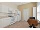 Bright kitchen with white appliances, stylish table, and tile flooring providing a fresh, functional space at 708 Foggy Morn Ln, Bradenton, FL 34212