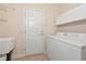 Functional laundry room features a washer and dryer with storage above, and door to exterior at 708 Foggy Morn Ln, Bradenton, FL 34212