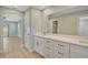 Bathroom with double vanity, white cabinets, and views to additional rooms at 7523 S Leewynn Dr, Sarasota, FL 34240