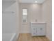 Bathroom featuring white vanity, tile surround, and wood-look floors at 7523 S Leewynn Dr, Sarasota, FL 34240