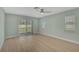 Bedroom with light green walls, wood floors, and sliding glass doors to outdoor space at 7523 S Leewynn Dr, Sarasota, FL 34240
