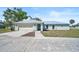 Inviting single-story home featuring a light blue exterior, metal roof, and spacious front yard at 7523 S Leewynn Dr, Sarasota, FL 34240