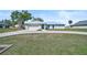 Beautiful single-story home featuring a spacious lawn, light blue exterior and a metal roof at 7523 S Leewynn Dr, Sarasota, FL 34240