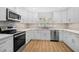 Modern kitchen featuring stainless steel appliances, light countertops, and stylish backsplash at 7523 S Leewynn Dr, Sarasota, FL 34240