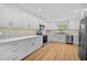 Updated kitchen with white cabinets, stainless steel appliances, and contemporary backsplash at 7523 S Leewynn Dr, Sarasota, FL 34240