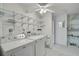 Bright laundry room featuring a washing machine, dryer, wash basin, and shelving with a ceiling fan at 7523 S Leewynn Dr, Sarasota, FL 34240