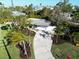 Aerial view of landscaped property with mature palms and green grass and a long driveway at 7701 Palm Dr, Holmes Beach, FL 34217