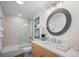 Bright bathroom featuring a modern vanity, decorative mirror, and shower-tub combo at 7701 Palm Dr, Holmes Beach, FL 34217