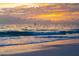 Beautiful beachfront view featuring gentle waves and a colorful sky at sunset at 7701 Palm Dr, Holmes Beach, FL 34217