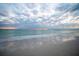Scenic beach view with a sunset featuring reflections on the wet sand and gentle waves at 7701 Palm Dr, Holmes Beach, FL 34217
