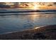 Picturesque beach with tranquil waves and reflections of the sunset sky on the wet sand at 7701 Palm Dr, Holmes Beach, FL 34217