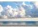 Expansive beach with white sand, clear blue waters, and a picturesque sky full of clouds at 7701 Palm Dr, Holmes Beach, FL 34217