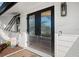 Beautiful modern front door with sidelight and modern exterior lighting at 7701 Palm Dr, Holmes Beach, FL 34217