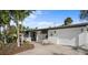 Charming single-story home with a well-manicured yard, palm trees, and a two-car garage at 7701 Palm Dr, Holmes Beach, FL 34217