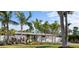 Charming single-story home with a manicured front yard with palm trees and beautiful landscaping at 7701 Palm Dr, Holmes Beach, FL 34217