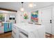 Bright kitchen with a large marble island, modern lighting, and beach-themed accents at 7701 Palm Dr, Holmes Beach, FL 34217